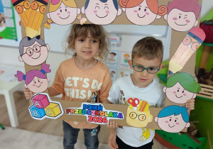 dzieci w ramce pozują do zdjęcia