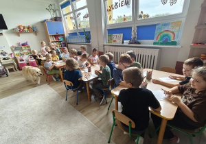 dzieci siedzą przy stolikach