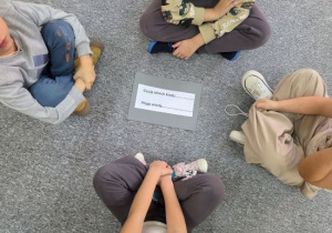 dzieci siedzą w kole