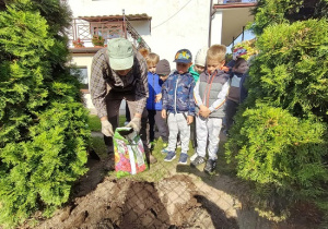 dzieci obserwują przygotowania do sadzenia roślin