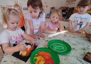 dziewczynka stempluje farbą wokół obrazka