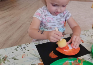 dziewczynka wykonuje swoja pracę plastyczną