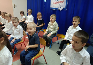 dzieci w strojach galowych występują dla publiczności