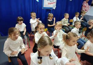 dzieci w strojach galowych występują dla publiczności