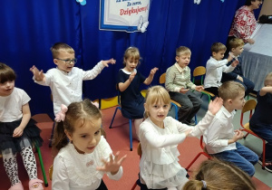 dzieci w strojach galowych występują dla publiczności