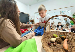 dziecko poznaje sensorycznie różne owoce i warzywa