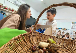 chłopiec poznaje sensorycznie różne owoce i warzywa
