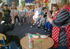 nauczycielka pokazuje dzieciom czyste ręce przygotowane do wyrabiania ciasta