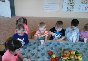 dzieci przy stolikach smakują musy owocowo- warzywne