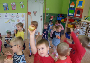 dzieci maszerują z jabłkami w ręku