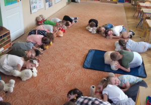 Dzieci ćwiczą na maskotkach wyczuwanie oddechu poszkodowanego