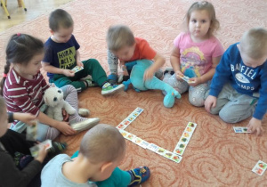 Dzieci z Panią Małgosią układają ,,Przyrodnicze domino''