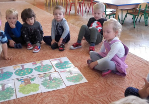 Dzieci słuchają opowieści nauczyciela nt. drzew