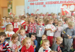dzieci w strojach biało- czerwonych odśpiewują hymn