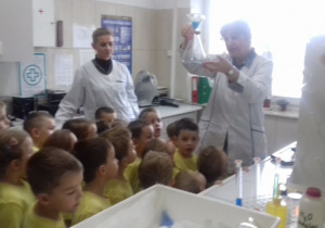 dzieci obserwują działania laboratoryjne