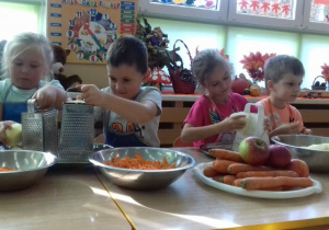 dzieci scierają jabłka na tarce