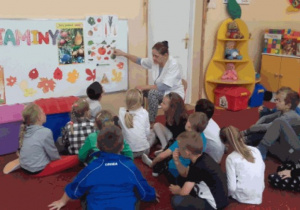dzieci oglądają plakat z owocami i warzywami