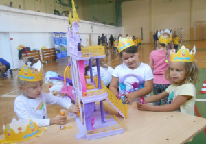 dziewczynki w koronach bawia się królewskim zamkiem