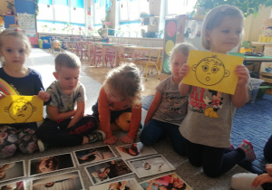 dzieci oglądają zdjęcia ukazujące różne emocje i próbują je nazywać