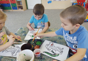 Emil i Adaś malują farbami smoka
