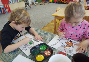 Wojtuś i Ola malują farbami smoka