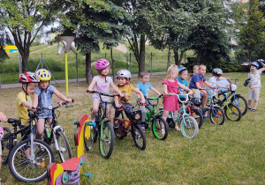 dzieci stoją ze sowimi rowerami na placu przedszkolnym