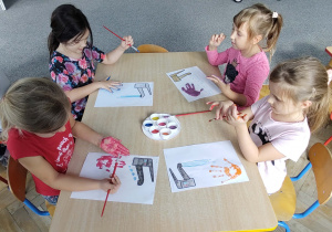 dziewczynki malują dłonie farbą
